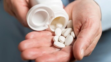 Tabletten werden in Hand geschüttet