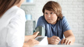 Adipösem Jungen wird Blutdruck gemessen