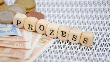 Würfel mit dem Wort Prozess auf Geld und Paragrafenzeichen