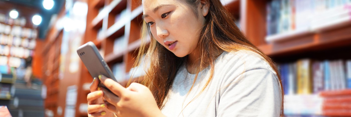 A young scientist looks at her phone screen