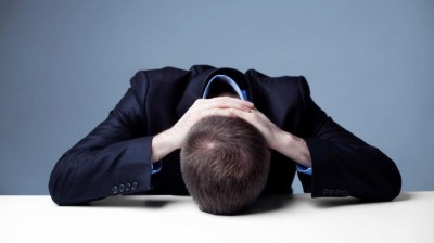 Man legt seinen Kopf auf die Tischplatte