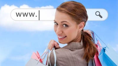 Junge Frau mit bunten Einkaufstüten in den Händen, im Hintergrund ein Suchschlitz mit www im Himmel. 