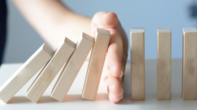 Hand unterbricht Dominoeffekt