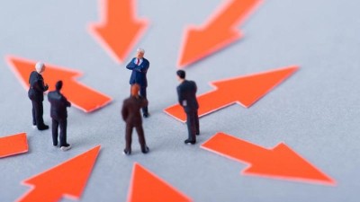 Menschen gehen auf Kreis aus Pfeilen am Boden zu