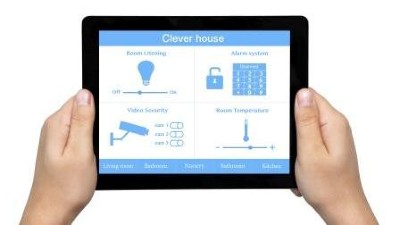 Zwei Hände halten ein Tablet mit der Aufschrift "Clever house" und Symbolen der intelligenten Gebäudetechnik