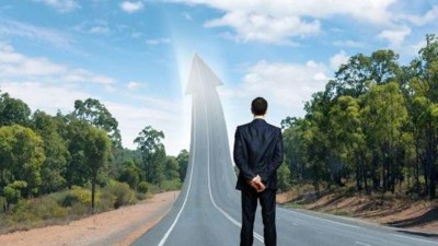 Geschäftsmann blickt auf steil ansteigende Straße