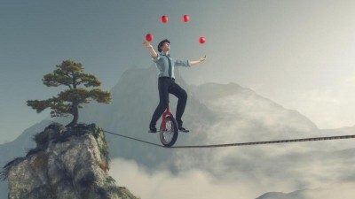 Jongleur fährt mit Einrad über ein Seil