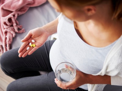 Schwangere nimmt Tabletten ein