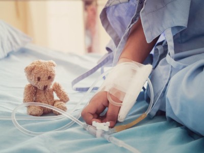 Kinderhand mit Infusion und Teddy