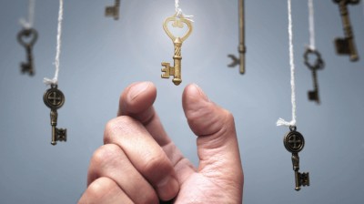 Hand greift nach einem von vielen Schlüsseln