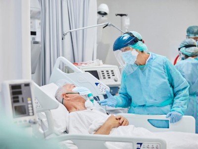 Ärztin spricht mit älterem COVID-19-Patienten