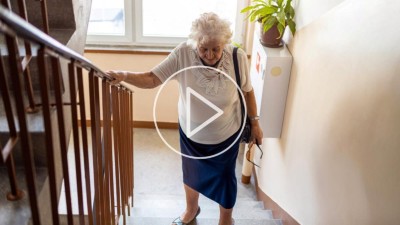 Alte Frau steigt Treppe hoch