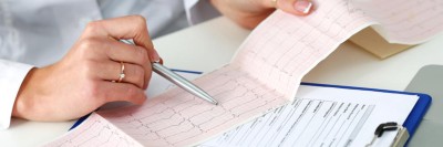 Ärztin überprüft EKG