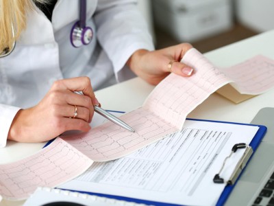 Ärztin überprüft EKG