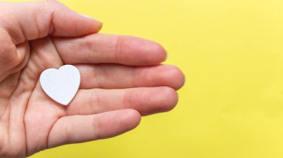 Hand hält weißes Herz