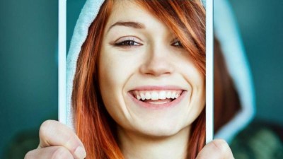 Frau hält Tablet hoch