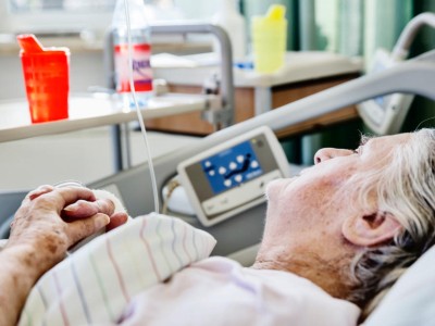 Seniorin liegt im Krankenhausbett