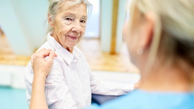 Seniorin wird von Personal betreut