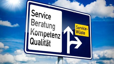 Straßenschild mit der Abfahrt "Service-Wüste" und der Weiterfahrt" Service, Beratung Kompetenz, Qualität"