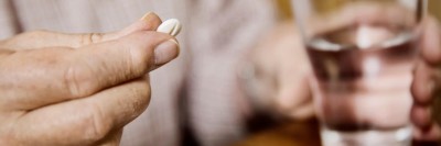 Person hält Tablette und Glas