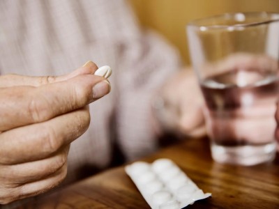 Person hält Tablette und Glas