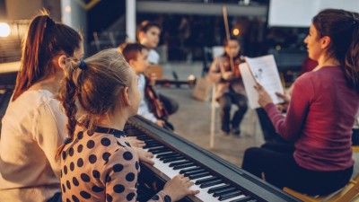 Eine Gruppe Kinder im Musikunterricht mit Lehrperson