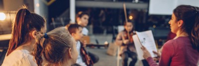 Eine Gruppe Kinder im Musikunterricht mit Lehrperson
