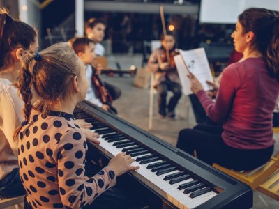 Eine Gruppe Kinder im Musikunterricht mit Lehrperson