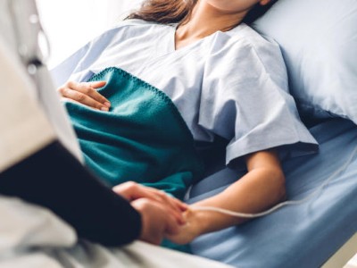 Medizinisches Personal hält Patientin die Hand