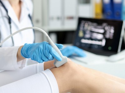 Ärztin führt Knieultraschalluntersuchung durch