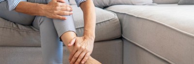 Eine Frau hält sich den Fuß am Knöchel