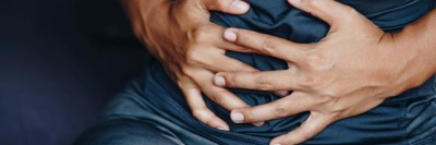 Person hält sich den Bauch