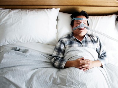 Mann mit Atemmaske im Bett