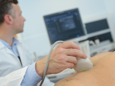 Arzt schallt einen älteren Patienten