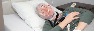 Frau mittleren Alters bekommt Polysomnographie im Schlaflabor