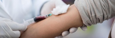 Frau wird Blut abgenommen