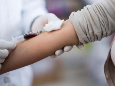 Frau wird Blut abgenommen