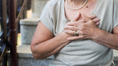 Ältere Frau hält sich die Hände an die Brust