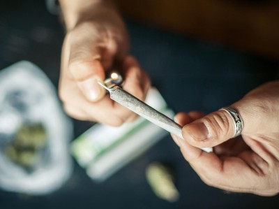 Cannabisraucher zündet sich einen Joint an