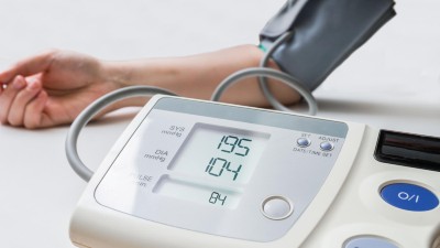 Frau misst Blutdruck mit digitalem Messgerät