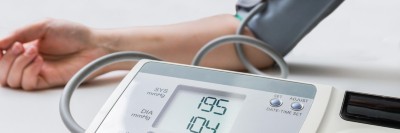 Frau misst Blutdruck mit digitalem Messgerät