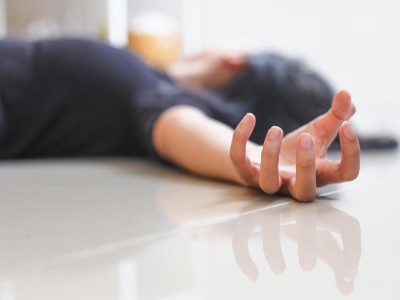 Junge Person liegt krampfend auf dem Boden