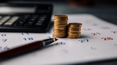 Münzen und Taschenrechner auf Kalender