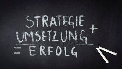 Tafel mit Schrift in weißer Kreide: Strategie + Umsetzung=Erfolg