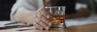 Schlafender Mann mit alkoholischem Getränk in der Hand