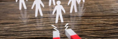 Ein rotes Hufeisen zieht weiße Papierfiguren an