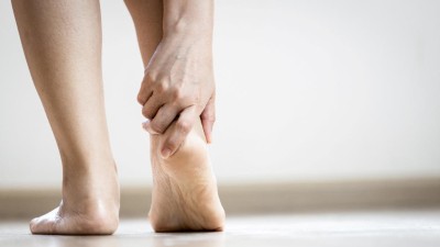 Frau greift an ihre Ferse