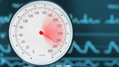 High blood pressure dial measurement with an ECG in the background