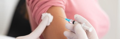 Person verabreicht Injektion in den Oberarm