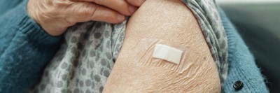 Ältere Frau mit Pflaster am Arm